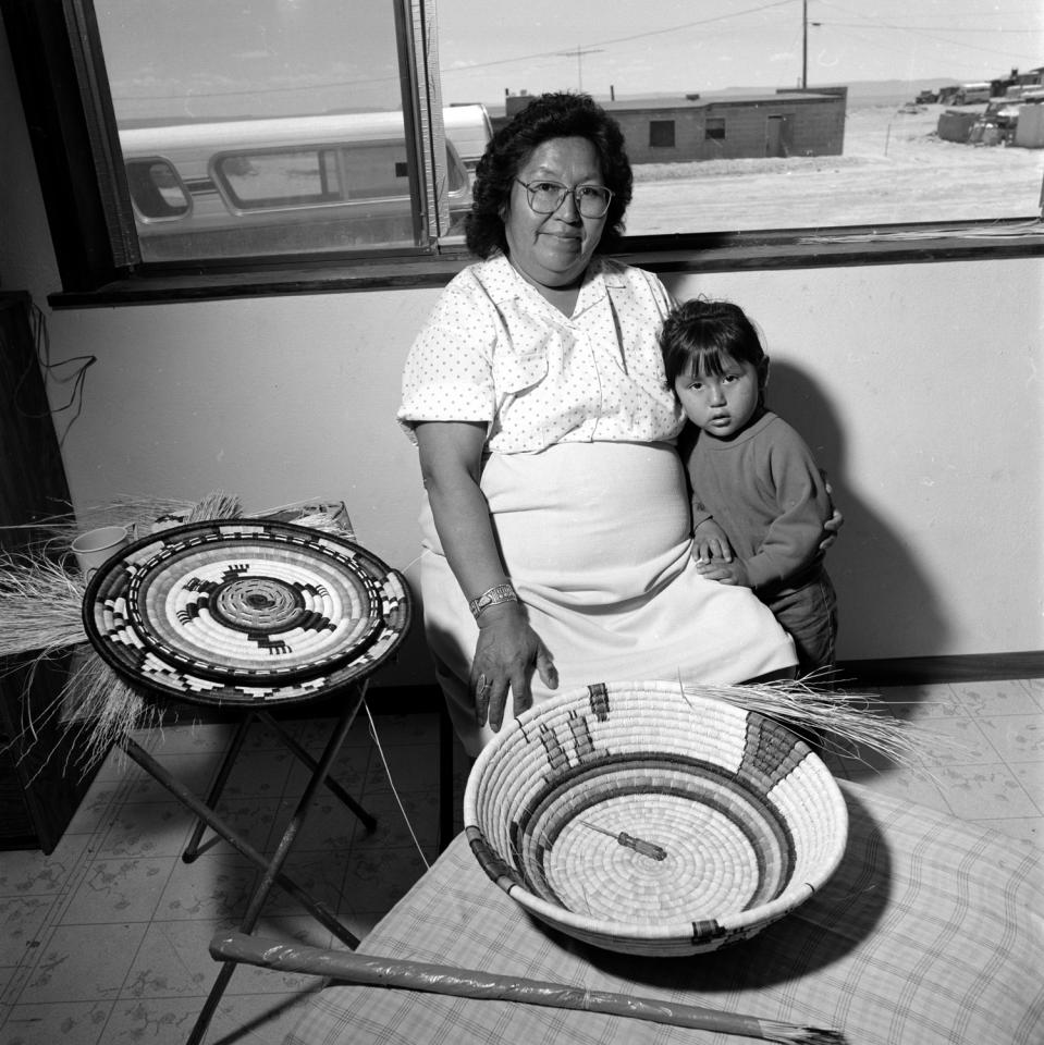 Madeline Lamson with her granddaughter and two coiled baskets