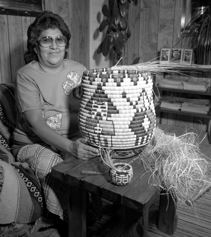 Retta Lou Adams with a large unfinished coiled basket decorated with Kachinas