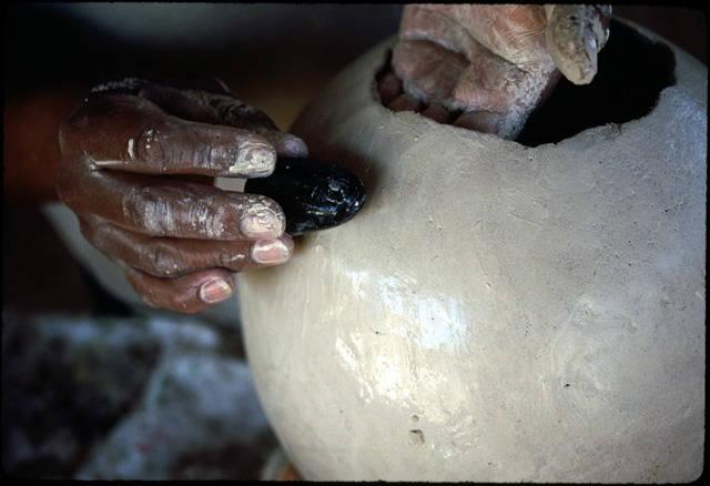 A polishing stone and water are used to smooth the surface before the pot is set to partially dry in the sun_image #14.jpg