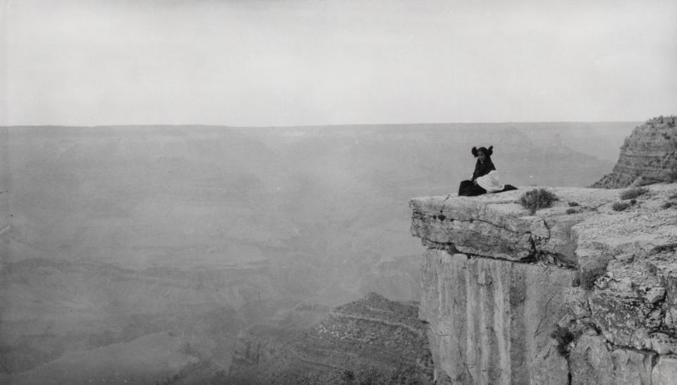 Hopi girl sitting at the edge of mesa